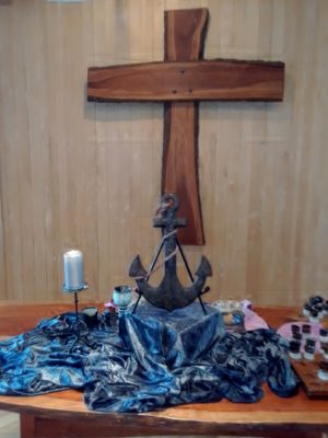 The altar with an anchor, shiny blue cloth, and communion cups